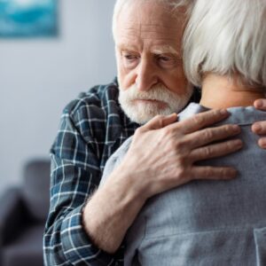 back view of senior woman hugged by husband, sick on dementia