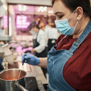 Professional kitchen staff following food handling safety protocols