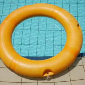 Red life buoy in swimming pool.. Help and support concept.
