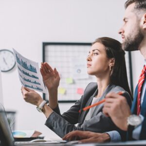 Side view of data analysts using charts while assessing risk in office